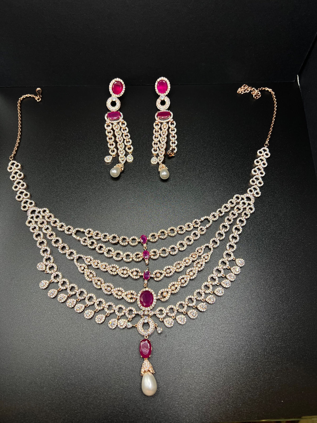 Rose gold and pink five layered necklace with dangle earrings.